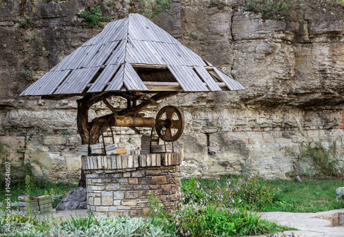 Old wooden well in the grass photo