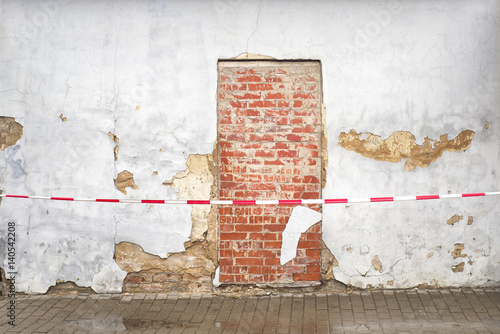 cracked brick wall and bricked up door photo