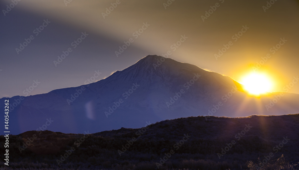 Sunset over color mountain silhouette with rays