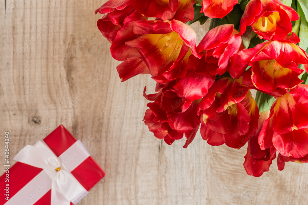 red tulips and gift on wooden background red tulips and gift on wooden background