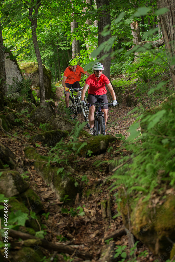 Couple Mountain Biking on Single Track in the Forest