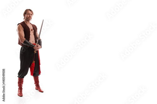 actor male barbarian in trousers with naked torso posing on a white background in studio