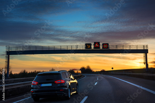 Verkehrsleitsystem Tempo 80 auf Autobahn A6 Baustellenwarnung im Sonnenuntergang