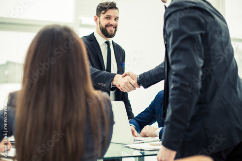 handshake business partners after discussion of the contract at the working place