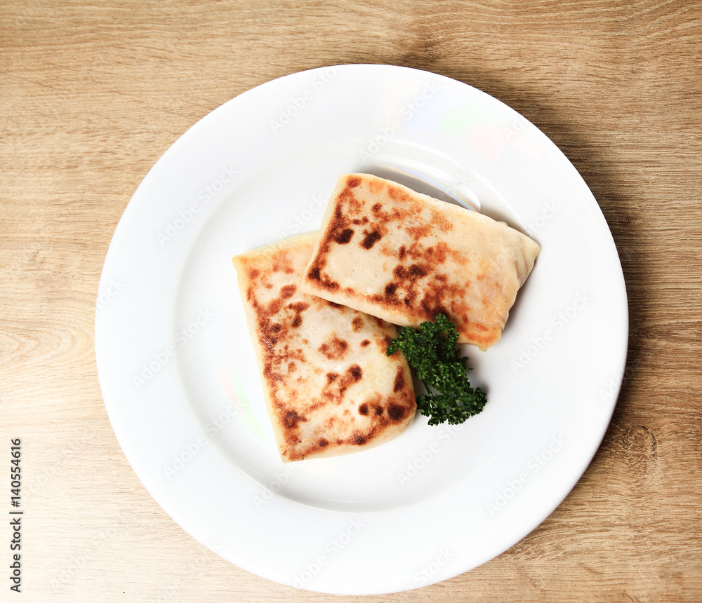 pancakes on white plate on wooden background