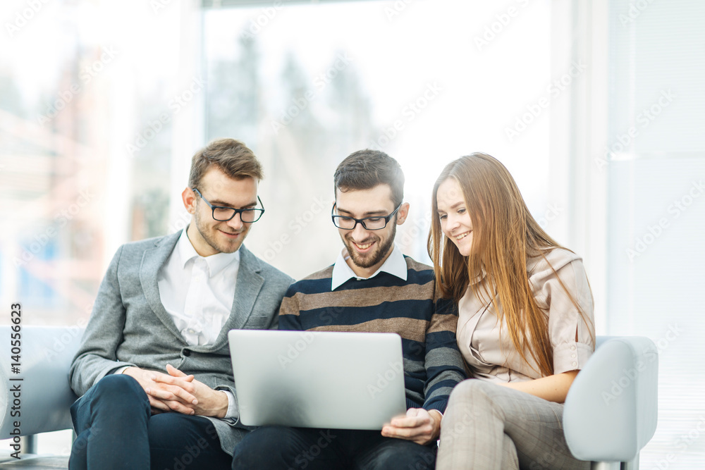  employees with a laptop sitting in the lobby of the office