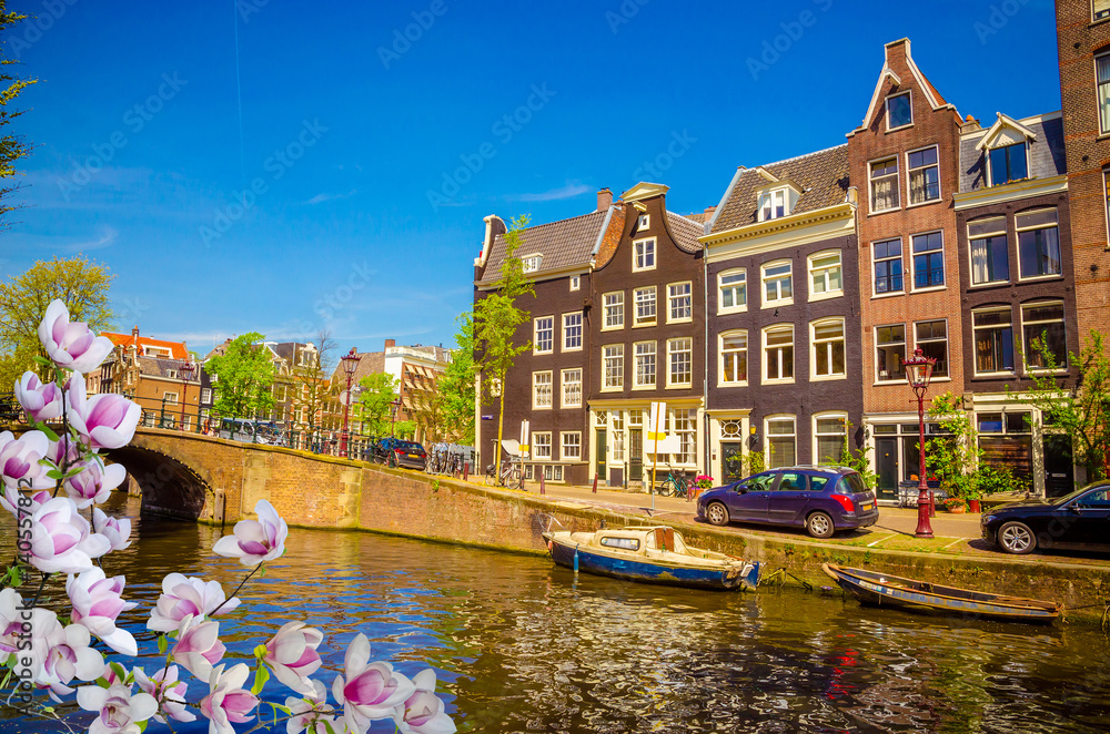 Obraz premium Traditional old buildings and and boats in Amsterdam, Netherlands. Canals of Amsterdam.
