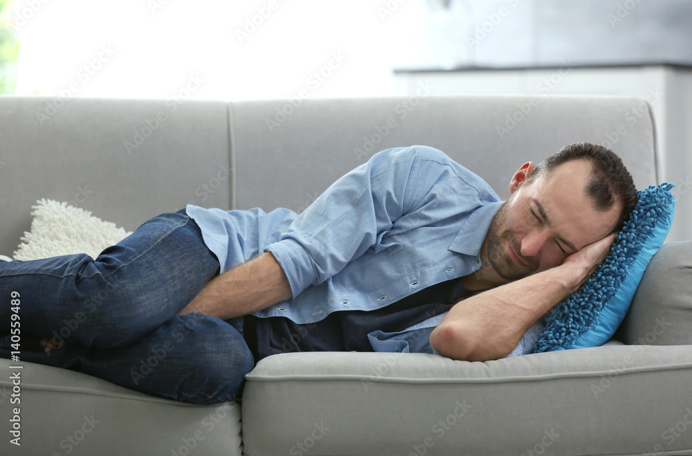 Handsome depressed man lying on sofa at home Handsome depressed man lying on sofa at home