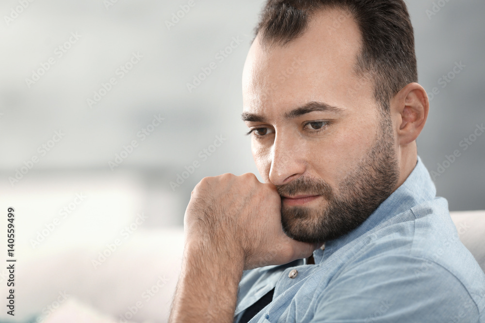 Obraz premium Portrait of handsome depressed man at home