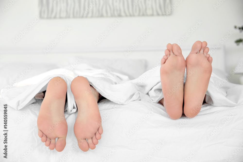 Feet of young cute couple together in bed Feet of young cute couple together in bed