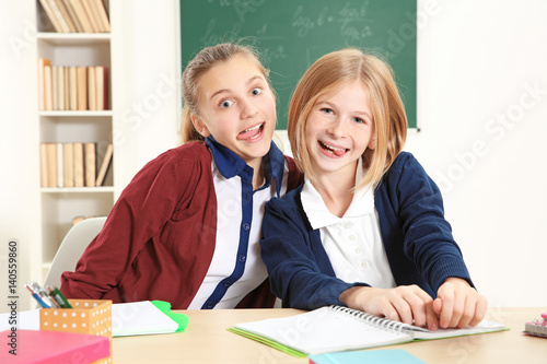 Two cute girls sitting at d...