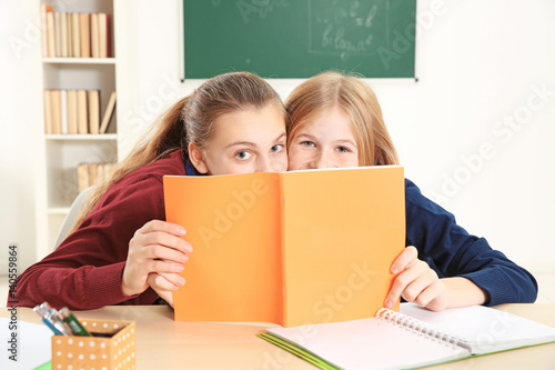 Two cute girls sitting at d...