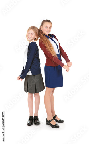 Two cute girls in school uniform on white background