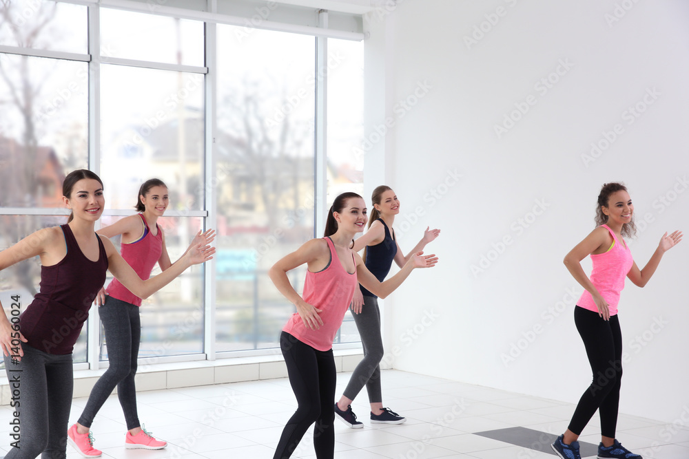 Fototapeta premium Young sporty women training in dance hall