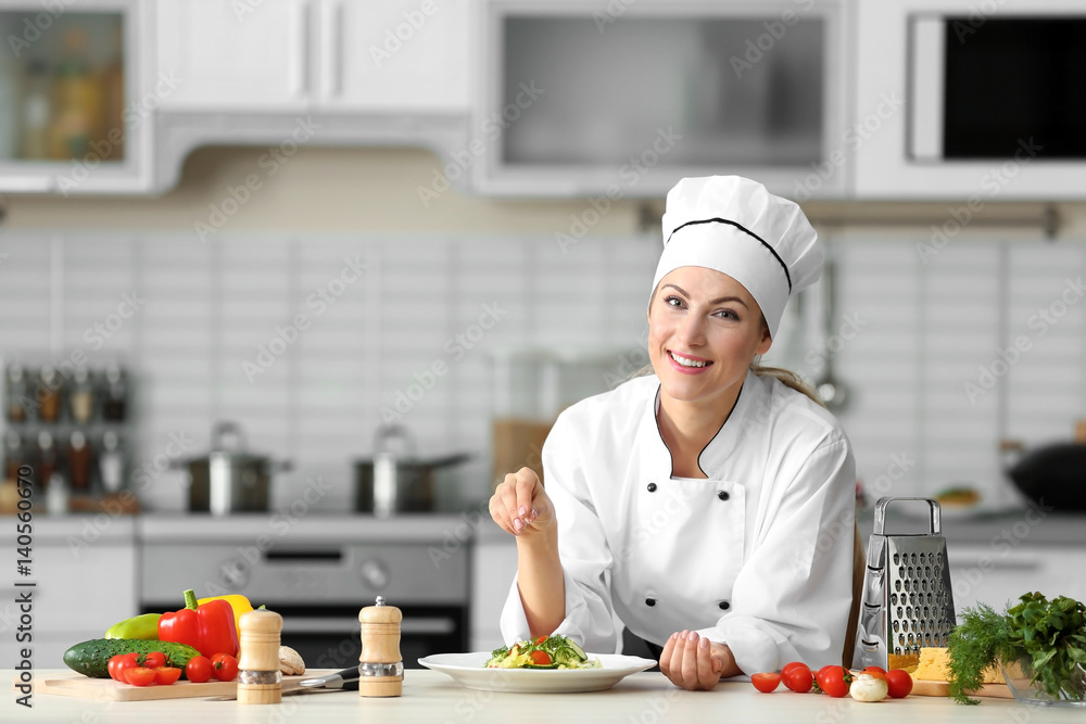 Female chef salt vegetable salad in kitchen Female chef salt vegetable salad in kitchen