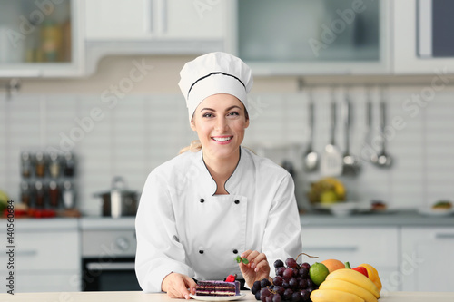 Female chef decorating cake...