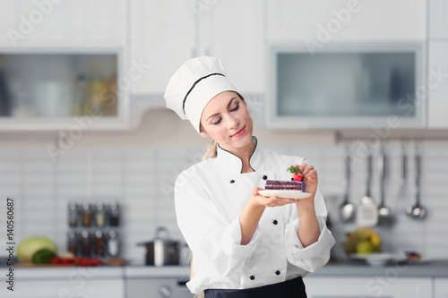Obraz na płótnie Female chef decorating cake in kitchen
