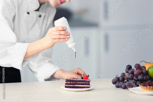 Female chef decorating cake...