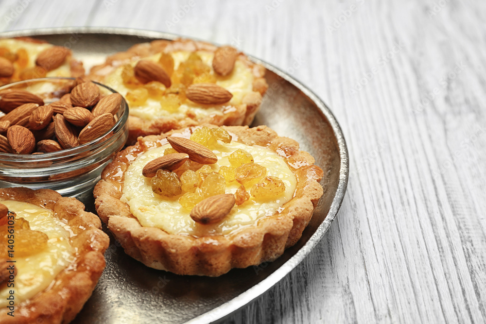 Metal tray with delicious crispy tarts on wooden background