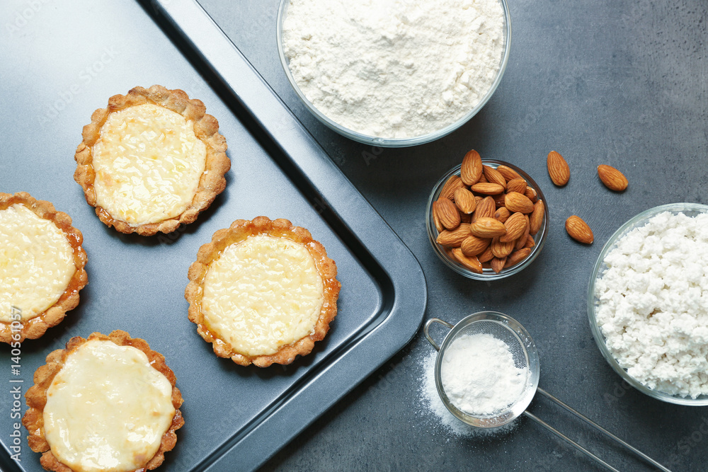 Baking tray with delicious crispy tarts on table Baking tray with delicious crispy tarts on table