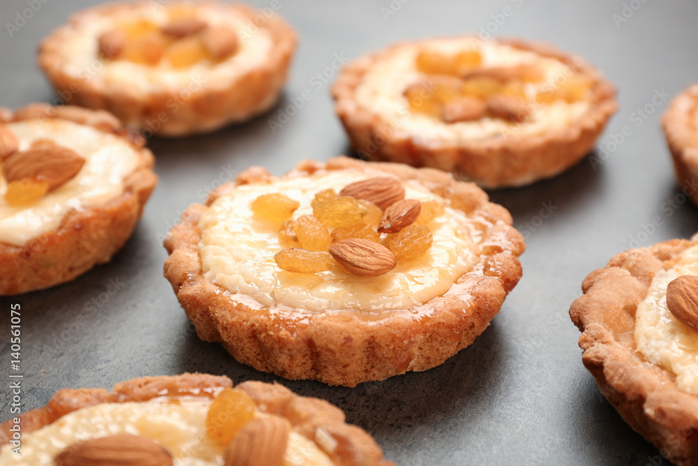 Delicious crispy tarts with almond and raisins on table