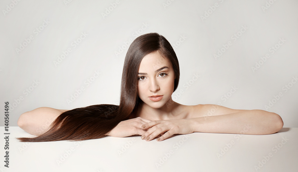 Beautiful young woman with long straight hair on light background Beautiful young woman with long straight hair on light background
