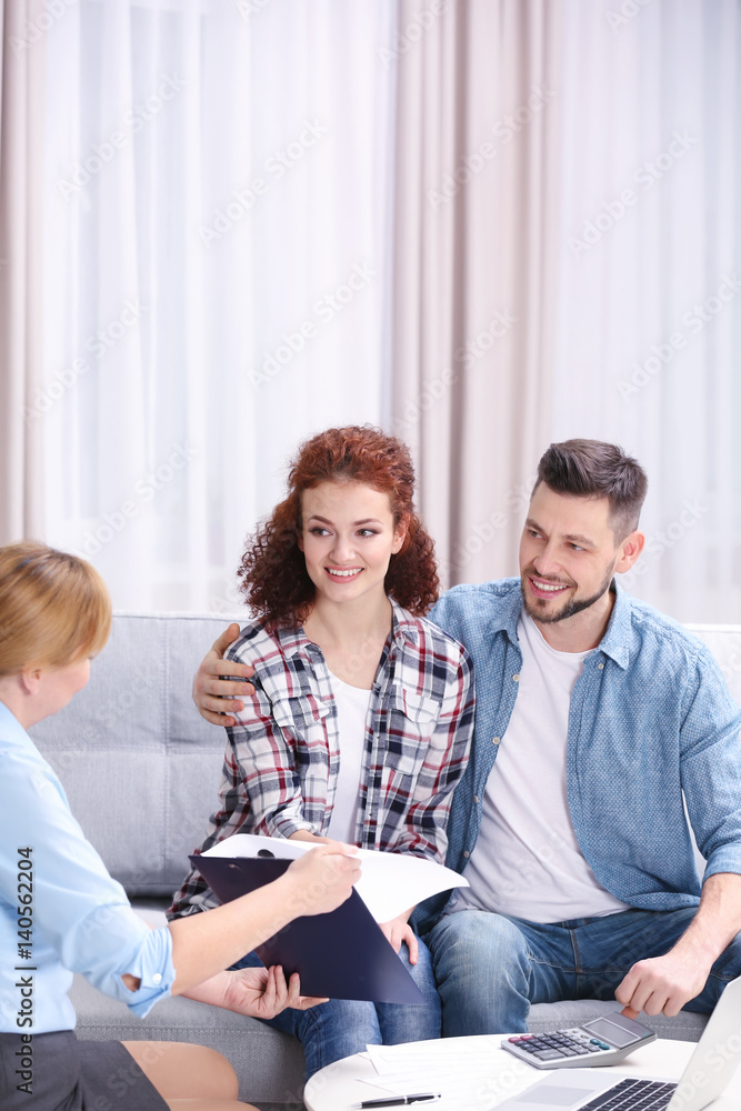 Young couple signing contract sitting on couch at home Young couple signing contract sitting on couch at home