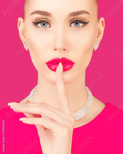 Portrait of an elegant young woman on a pink background