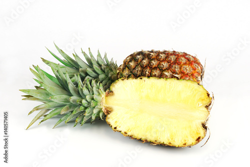whole pineapple and cut in half isolated on white background
