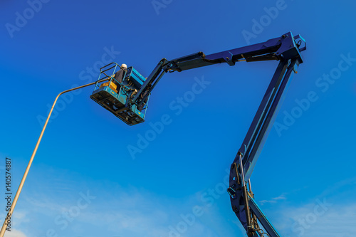 Electric technical repairing street light by boom lift in industrial
