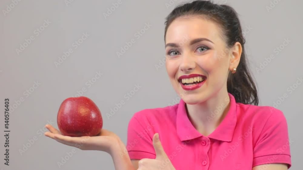 Happy beautiful girl holding red apple, thumbs up Happy beautiful girl holding red apple, thumbs up