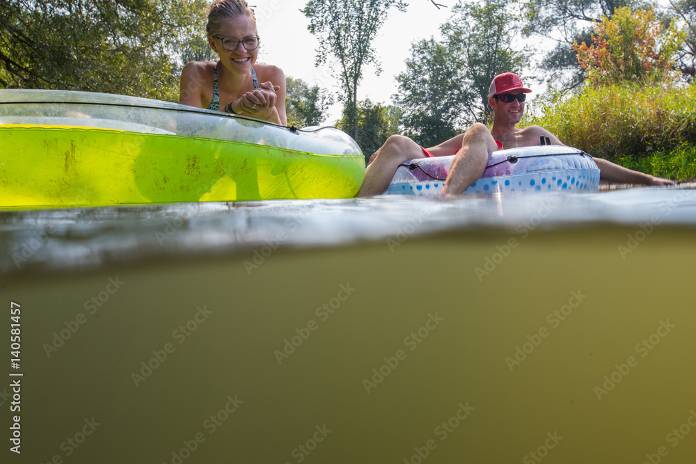 Couple tubing down the river in the summer