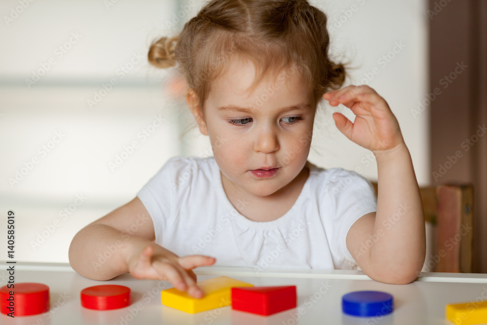 Little cute little girl plays with Geometric figures, indoor Little cute little girl plays with Geometric figures, indoor