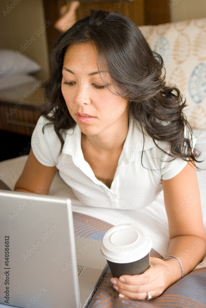Woman Relaxing On Bed Using Laptop Computer Woman Relaxing On Bed Using Laptop Computer