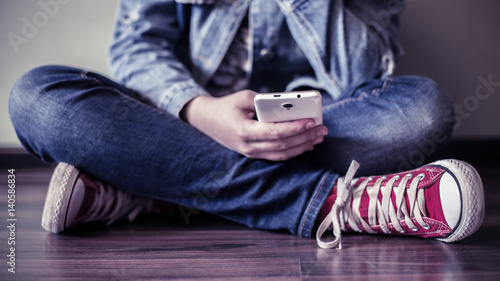Teenager uses a smartphone.
