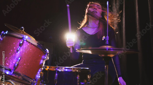 Teen rock music - girl with flowing hair percussion drummer performing with drums