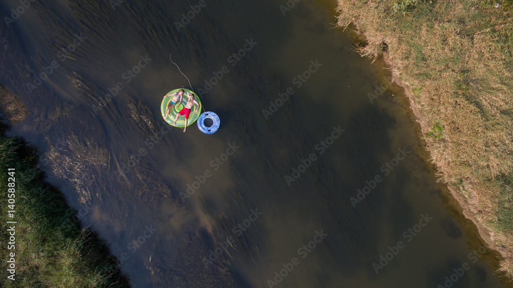 Aerial photo of a couple tubing down the river