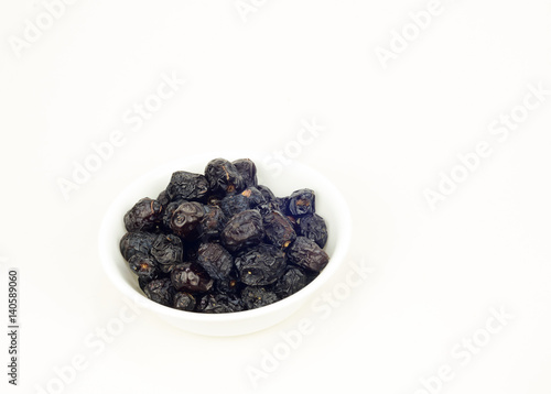 Dates in a white bowl over white background