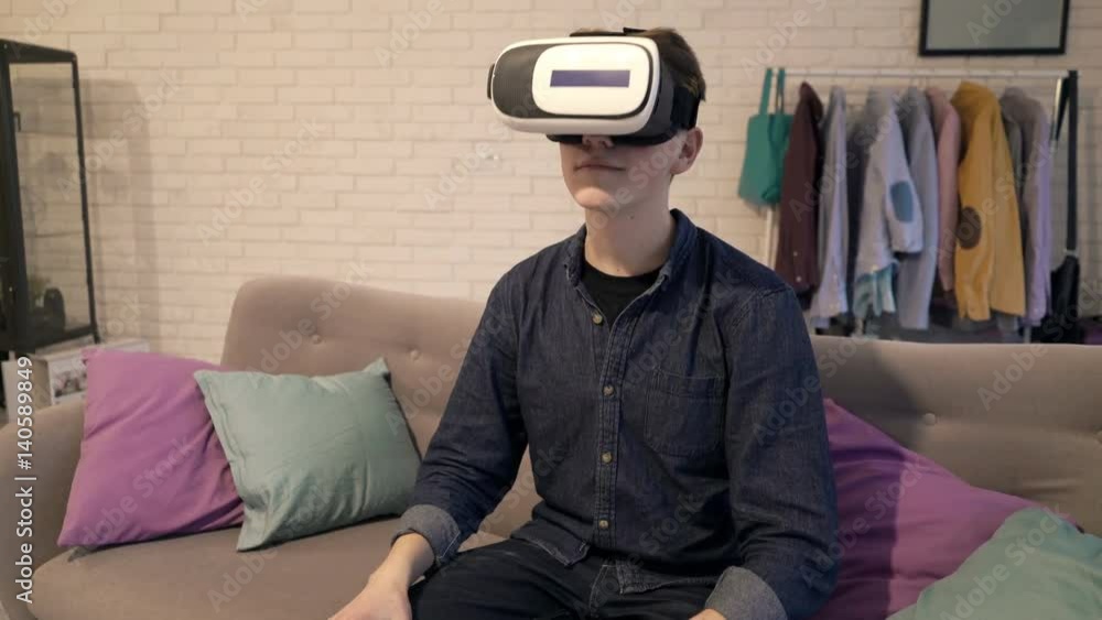 Young boy with vr goggle watching video sitting on sofa at home
Young boy with vr goggle watching video sitting on sofa at home