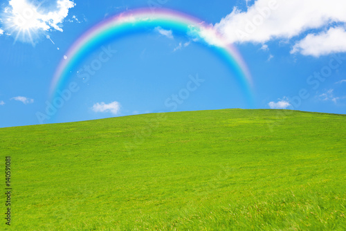 idyllic landscape of green heels  blue sky and rainbow