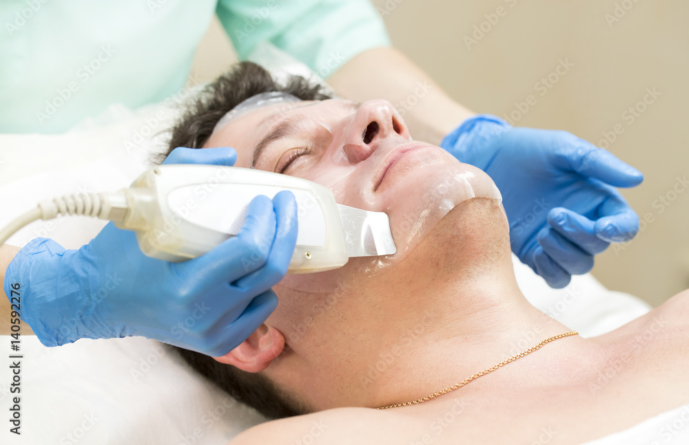 Man in the mask cosmetic procedure in spa salon Man in the mask cosmetic procedure in spa salon