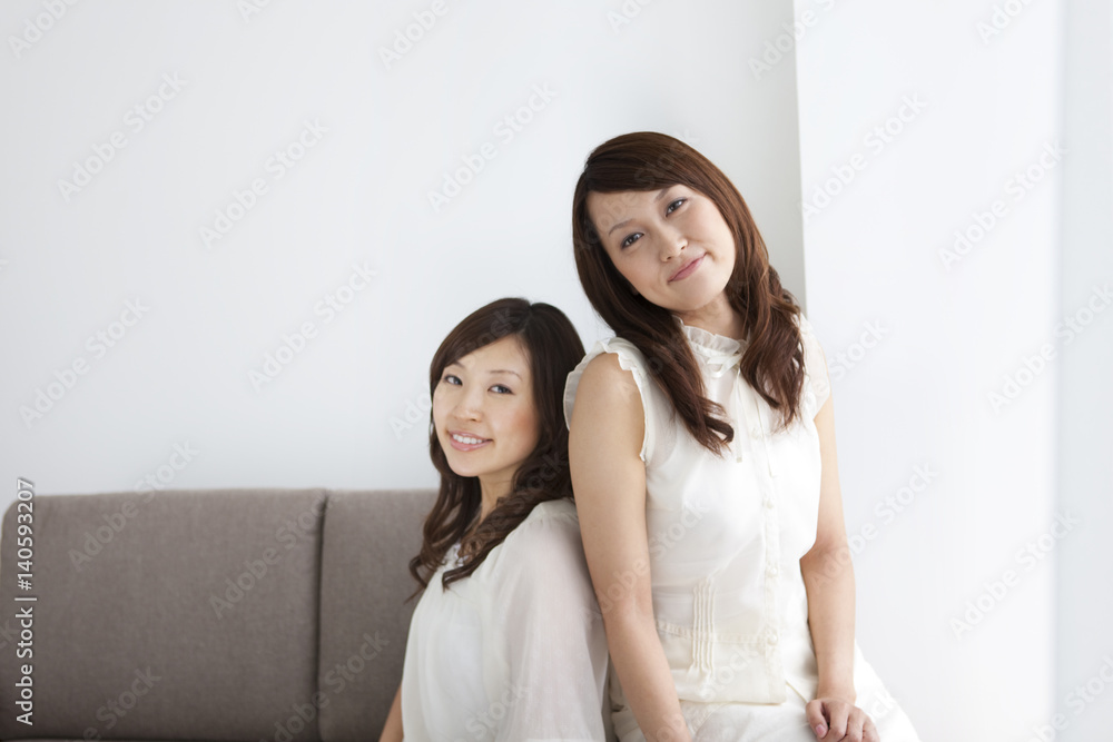 Women sitting on sofa looking at camera Women sitting on sofa looking at camera