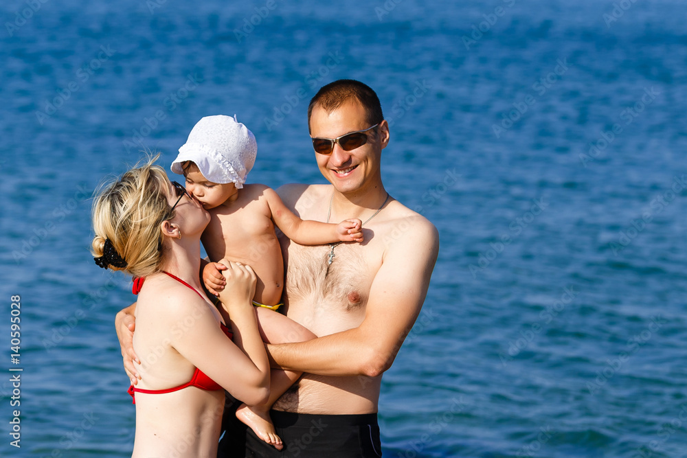 Dad holding a baby on its back to the sea Dad holding a baby on its back to the sea