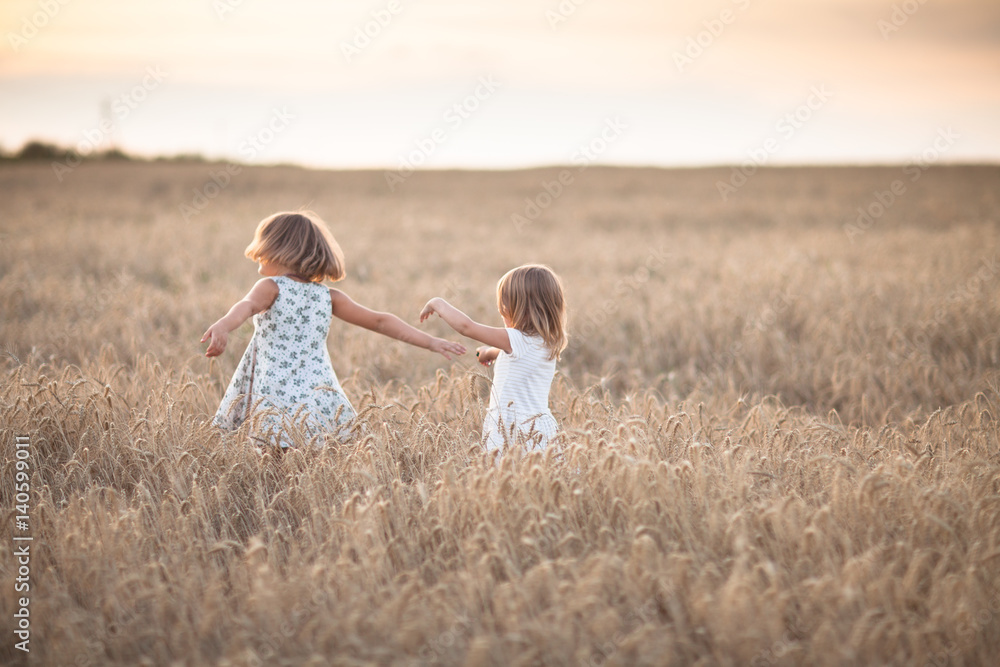 Fototapeta premium Two emotional sisters girls dance at sunset