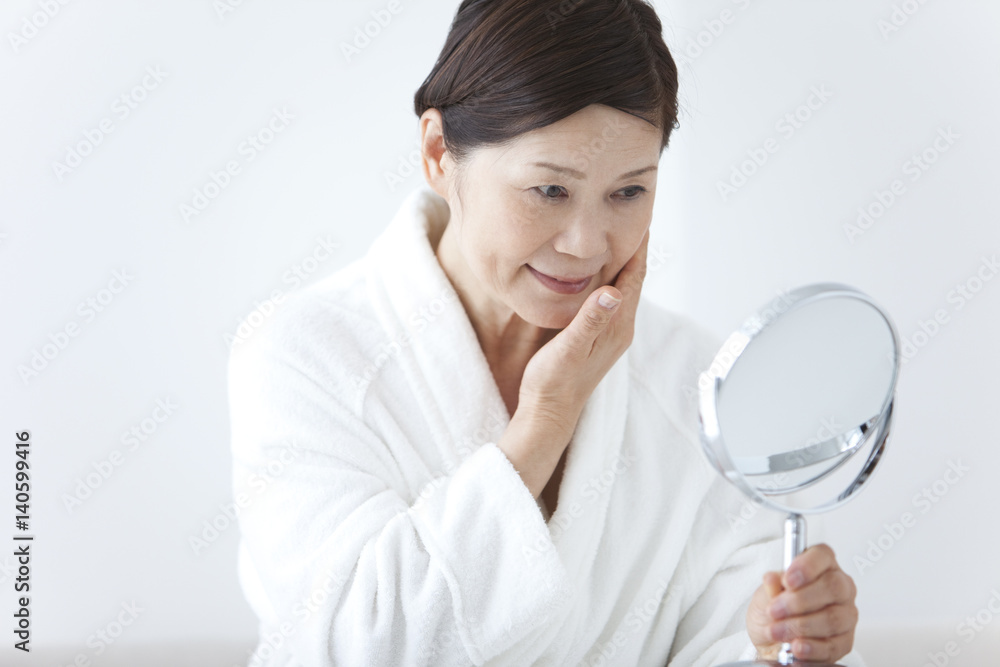 Middle-Aged Woman Wearing Bathrobe Using Mirror Middle-Aged Woman Wearing Bathrobe Using Mirror