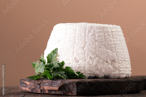 A fresh ricotta cheese with parsley leaf on wooden table, italian food