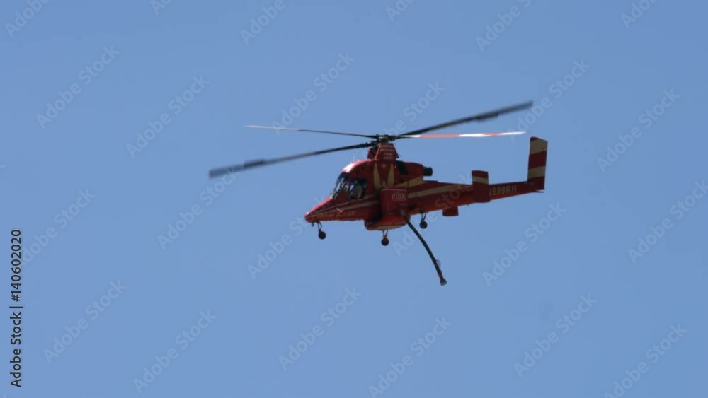 Firefighter helicopter dangles a hose as it flies Firefighter helicopter dangles a hose as it flies