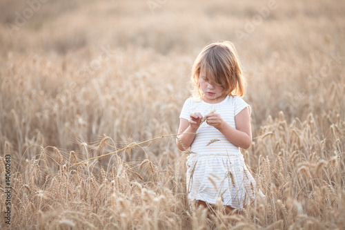 Emotional child on wheat field at sunset,pastel