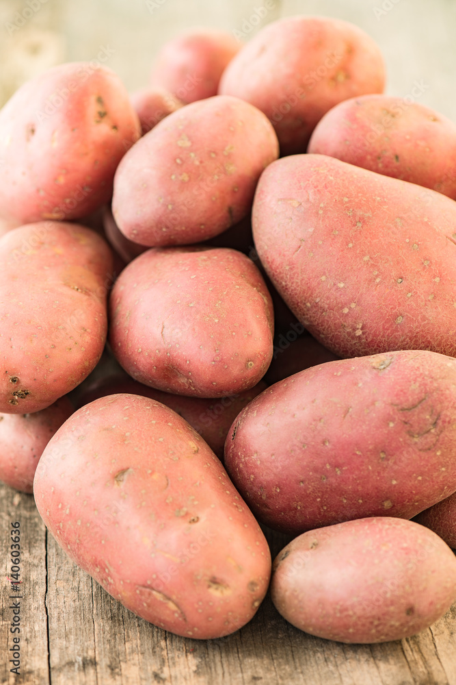 Pile of potatoes lying on wooden boards, fresh organic potatoes sold on market. Pile of potatoes lying on wooden boards, fresh organic potatoes sold on market.