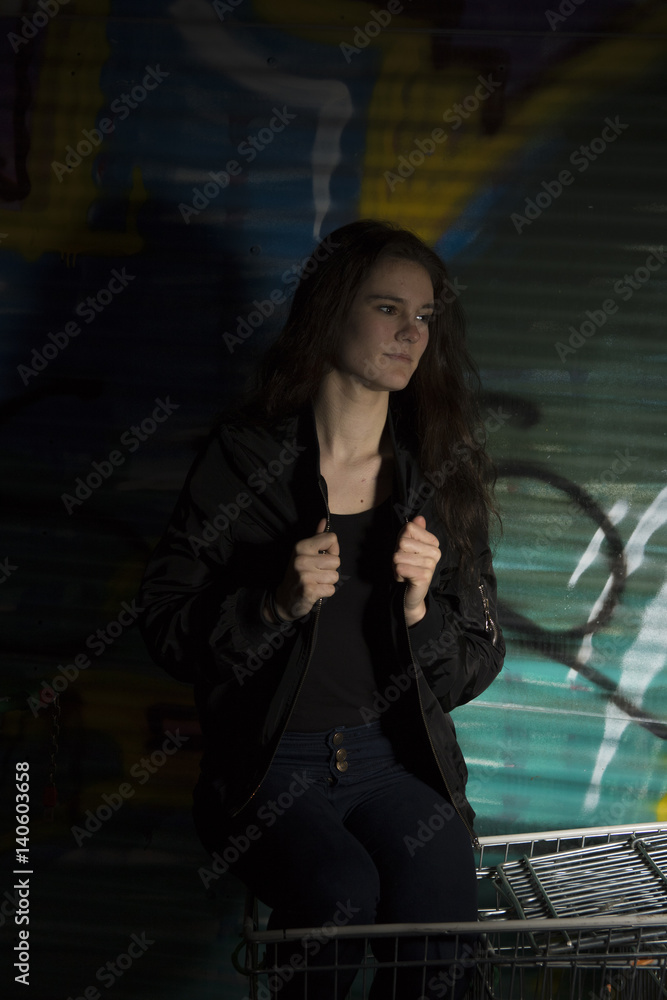 Obraz premium tough girl in front of Graffiti Wall